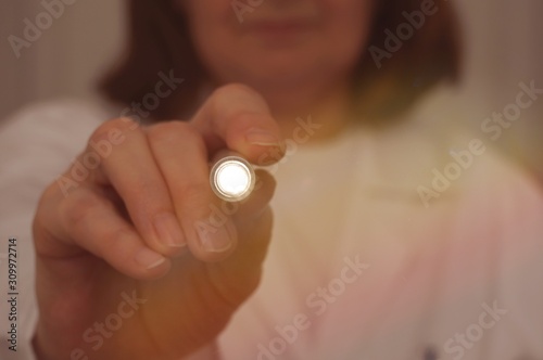 Female doctor pointing light direct to camera. Physical examination. Medical test. Postoperative care.