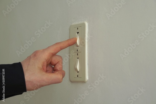 Finger pushing on off button. Top button activated on double switch power button. Switch light on.