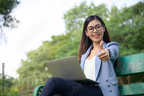 businesswomen working with laptop in the garden morning with coffee cup