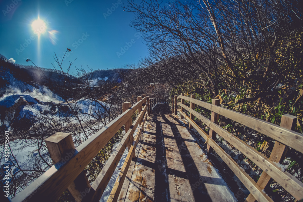 The wooden walking footpath trail bring to hot springs. Beautiful landscape view of Noboribetsu Jigokudani or Hell Valley in winter seasonal at Hokkaido, Japan.