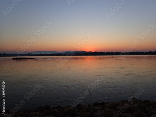 夜明けの国境の川をすすむボート © nori