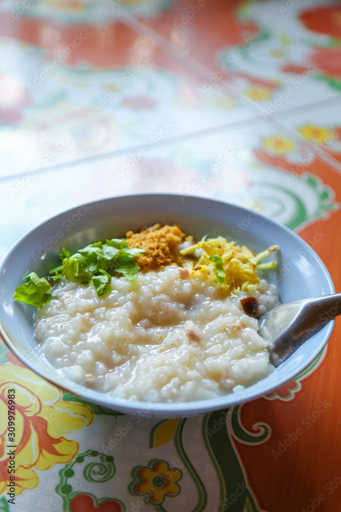 Congee with pork minced and thai celery and deep fried garlic minced.and sliced ginger breakfast or street food in Thailand Congee with pork minced and thai celery and deep fried garlic minced.and sliced ginger breakfast or street food in Thailand