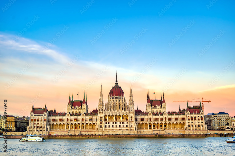 The Hungarian Parliament Building located on the Danube River in Budapest Hungary at sunset.