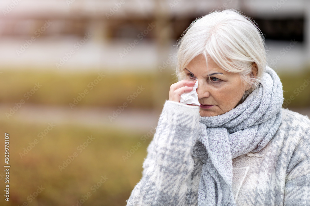 Weeping old woman wipes her eyes with tissue Weeping old woman wipes her eyes with tissue