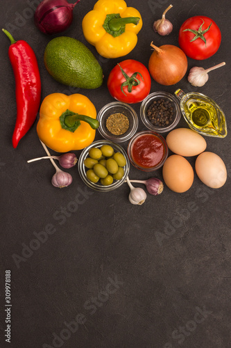 A set of vegetables for a healthy diet, yellow and red peppers, tomatoes, onions, garlic, eggs, olives, rocket, spinach. .