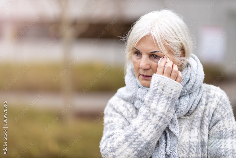 Weeping old woman wipes her eyes with tissue Weeping old woman wipes her eyes with tissue