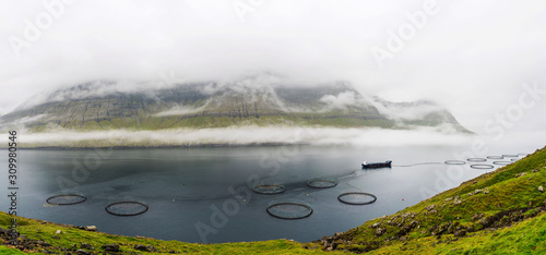 Faroe Islands landscape panorama with fish farms in between two islands.