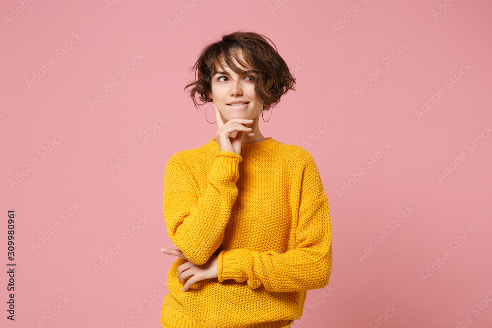 Pensive young brunette woman girl in yellow sweater posing isolated on pastel pink background, studio portrait. People lifestyle concept. Mock up copy space. Put hand prop up on chin, looking aside. Pensive young brunette woman girl in yellow sweater posing isolated on pastel pink background, studio portrait. People lifestyle concept. Mock up copy space. Put hand prop up on chin, looking aside.