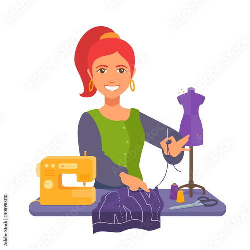 Tailor holding thread with a needle, smiling. Fabric cutting, pattern, sewing machine, mannequin, scissors, spools on the work table. 