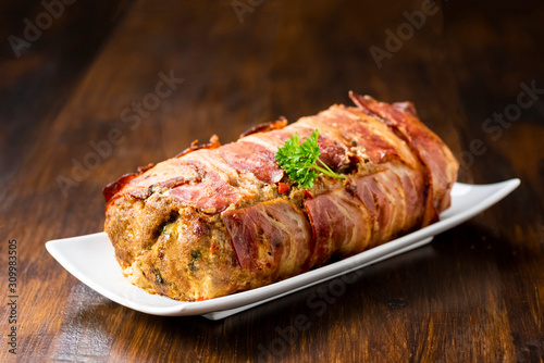 Photos baked roulade of minced meat surrounded by bacon
