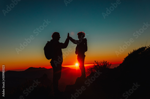 father with son travel in sunset mountains