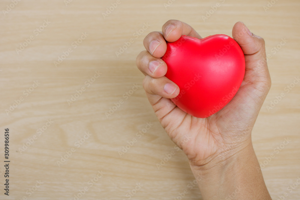 Red heart on hand on wooden background. Red heart on hand on wooden background.