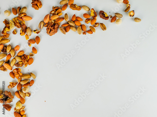 Healthy nut mix making an interesting and random frame on a left upper corner of image, representing the healthy nutritional diet