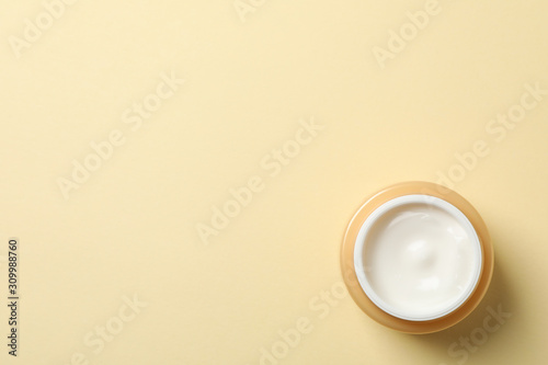 Jar of winter cream for skin on yellow background  space for text. Top view