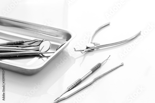 Dental instruments in stainless steel tray on white background close up