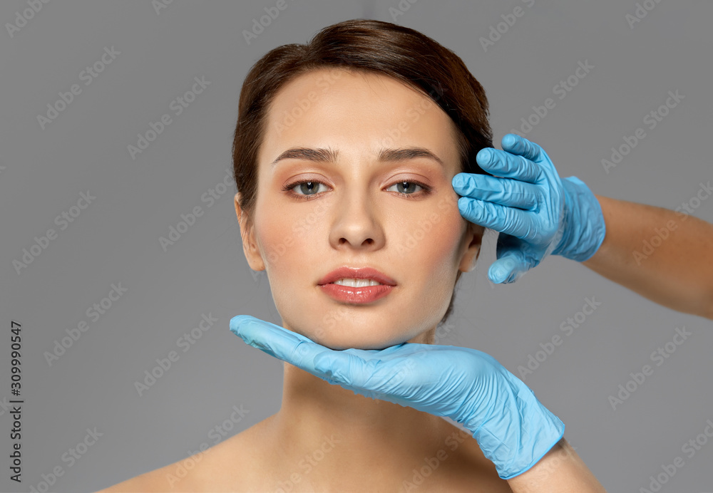 cosmetology, plastic surgery and beauty concept - beautiful young woman face and hands in surgical gloves over grey background and snow cosmetology, plastic surgery and beauty concept - beautiful young woman face and hands in surgical gloves over grey background and snow