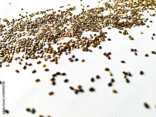 Closeup of healthy chia seed superfood on white background, raw and organic black seed chia placed randomly on table