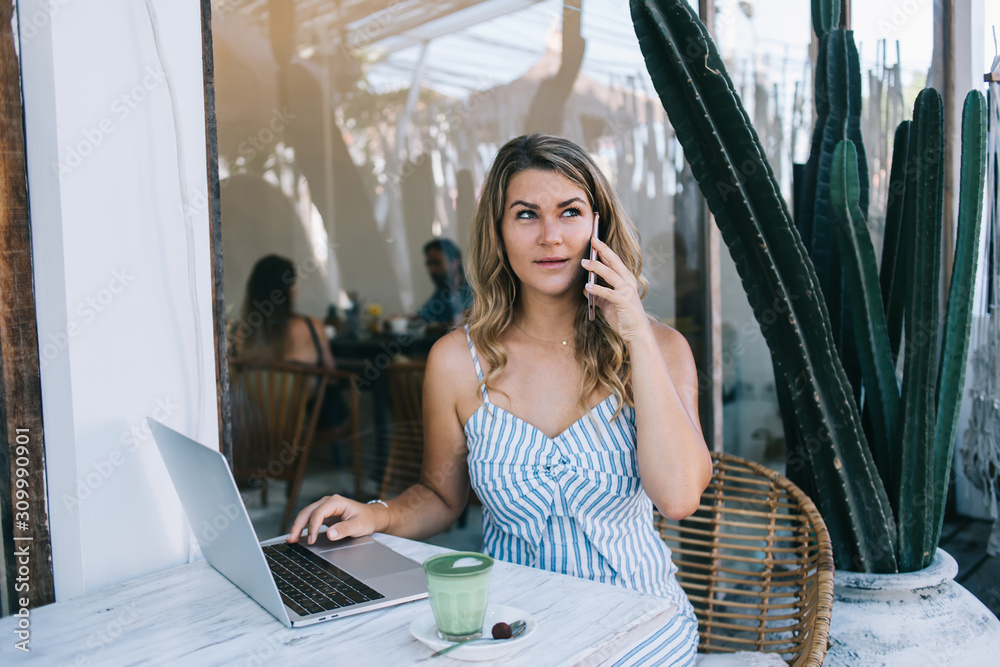 Fototapeta premium Concentrated woman speaking on smartphone at terrace