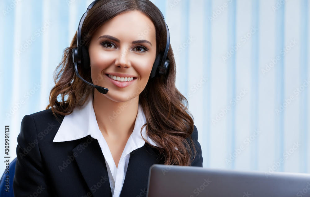 Portrait picture of customer support female phone operator or sales agent in headset and confident black suit, working with laptop at office workplace. Consulting and assistance service call center. Portrait picture of customer support female phone operator or sales agent in headset and confident black suit, working with laptop at office workplace. Consulting and assistance service call center.