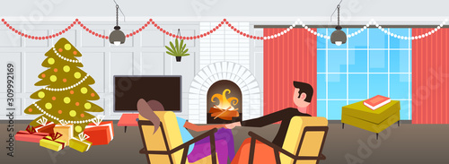 couple sitting near fireplace xmas new year winter holidays celebration concept man woman holding hands relaxing in christmas evening modern living room interior horizontal rear view vector