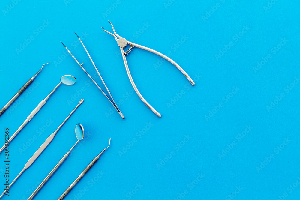 Stomatological tools on dentist's desk on blue background top-down pattern frame copy space Stomatological tools on dentist's desk on blue background top-down pattern frame copy space