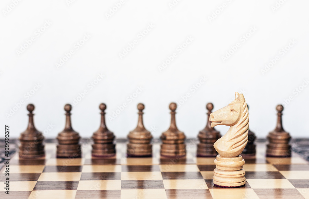 Wooden black and white chess pieces on a chessboard, horse and pawns on the background, leadership retro concept. Wooden black and white chess pieces on a chessboard, horse and pawns on the background, leadership retro concept.