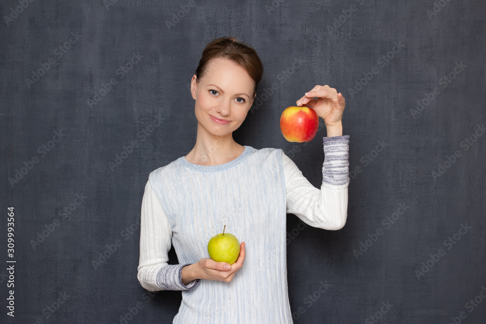 Portrait of happy girl smiling and holding two ripe apples in hands Portrait of happy girl smiling and holding two ripe apples in hands