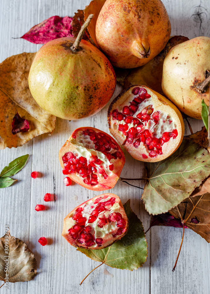 Pomegranate and ripe pomegranate fruit on white wooden rustic background. top view. Pomegranate and ripe pomegranate fruit on white wooden rustic background. top view.