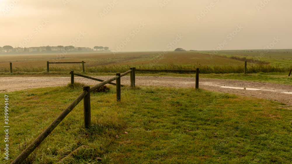 lo steccato del parcheggio e in lontananza la nebbia