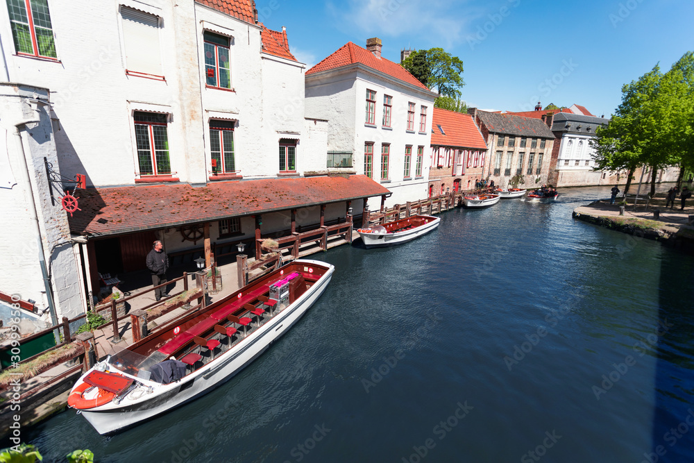 Cityscape of Bruges overlooking the canal and boats for excursions. Cityscape of Bruges overlooking the canal and boats for excursions.