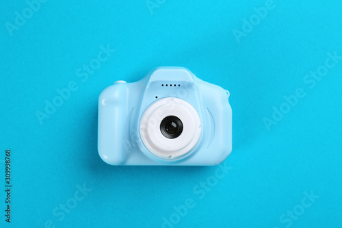 Toy camera on blue background, top view
