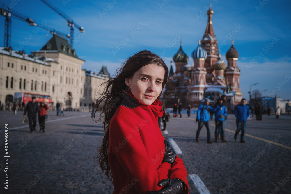 Fototapeta premium Happy women walking in red coat at the red square in Moscow