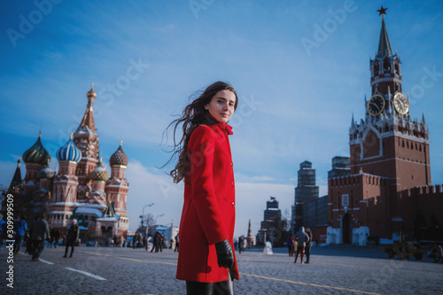 Happy women walking in red coat at the red square in Moscow
