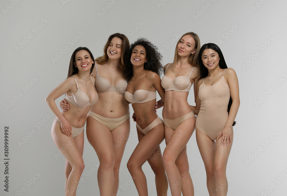 Group of women with different body types in underwear on light background  Stock Photo