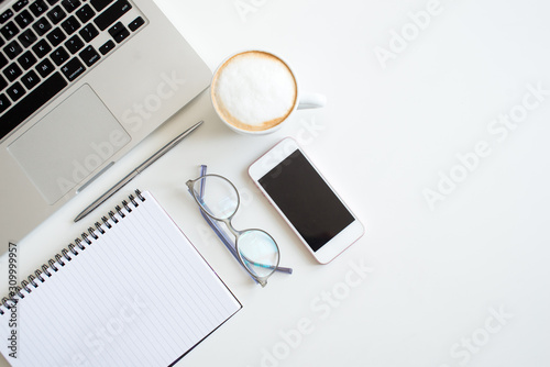 Home office desk in white colors with laptop, cup of coffee, notebook, phone, glasses on a white background. Flat lay Business womans workplace and objects. Top view. Copy space for text