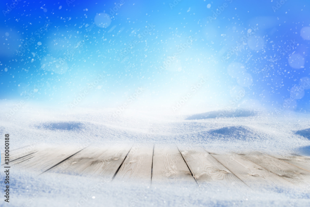 Decorative Christmas background with winter snowy blurred bokeh flakes of snow fall and empty wooden flooring