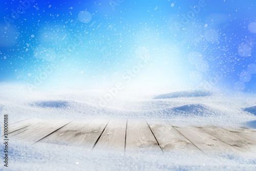 Decorative Christmas background with winter snowy blurred bokeh flakes of snow fall and empty wooden flooring © Aleksei