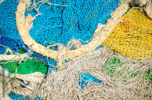 Colored blue and green fishing nets with yellow and orange floats close-up. Bright multi-colored backdrop. Hobby fishing concept. Copy space.