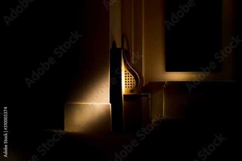 Empty wooden confessional in the old church in the sunlights photo