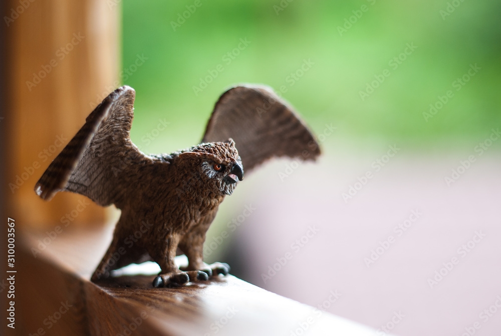 Fototapeta premium Owl toy figure sitting on a wooden bar