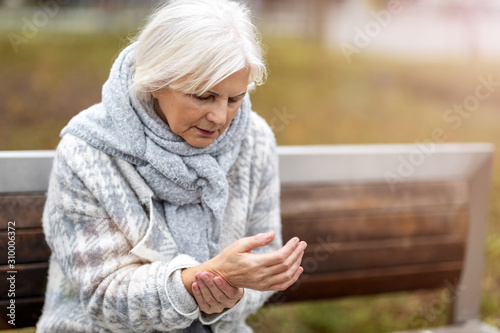 Tableau sur toile Senior woman with arthritis rubbing hands