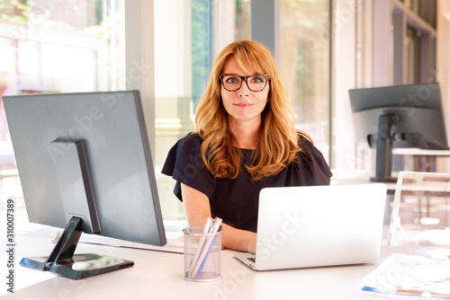 Executive businesswoman working on laptop in the office photo