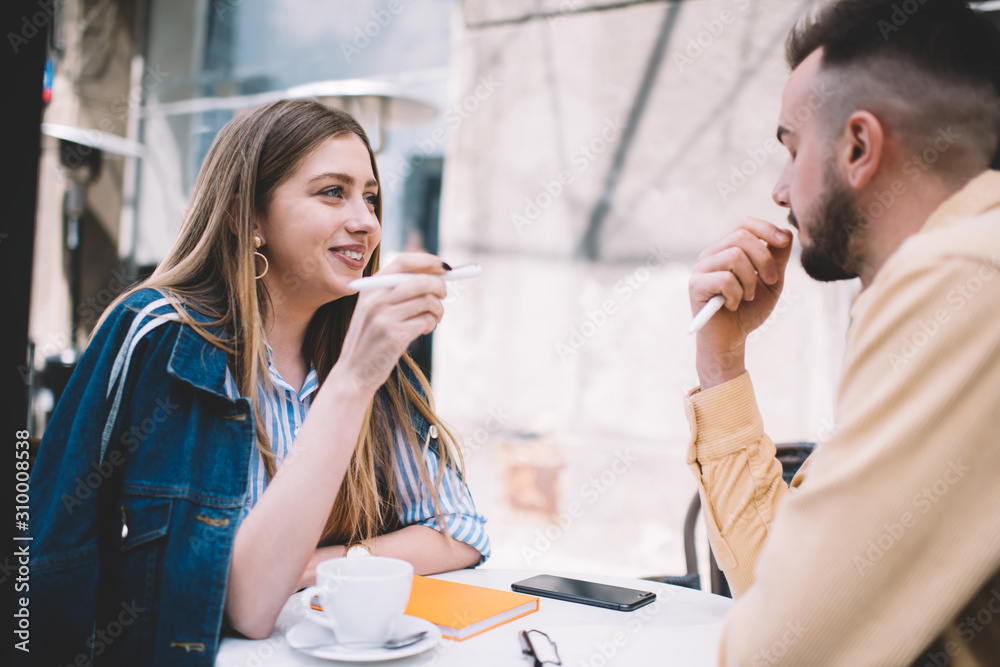 Happy fellows chilling in eatery and communicating