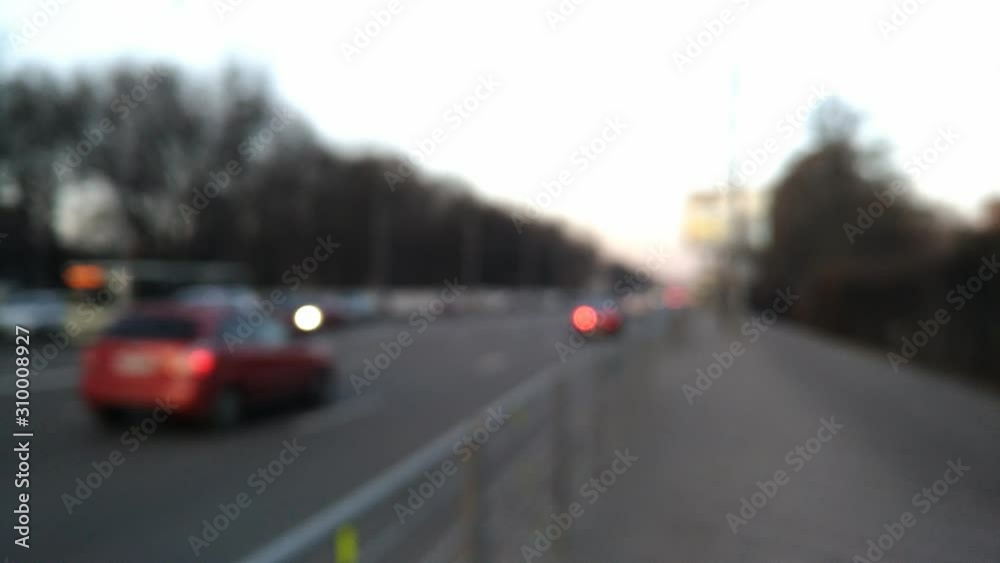 traffic in the city, unrecognisable cars with headlights moving in the street, blurred defocused view traffic in the city, unrecognisable cars with headlights moving in the street, blurred defocused view