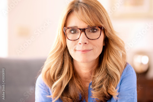 Portrait of attractive middle aged woman looking at camera and smiling to you