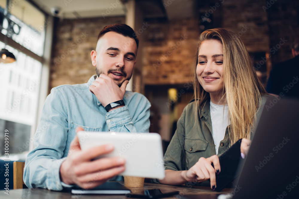 Cheerful couple watching tablet in cafe Cheerful couple watching tablet in cafe