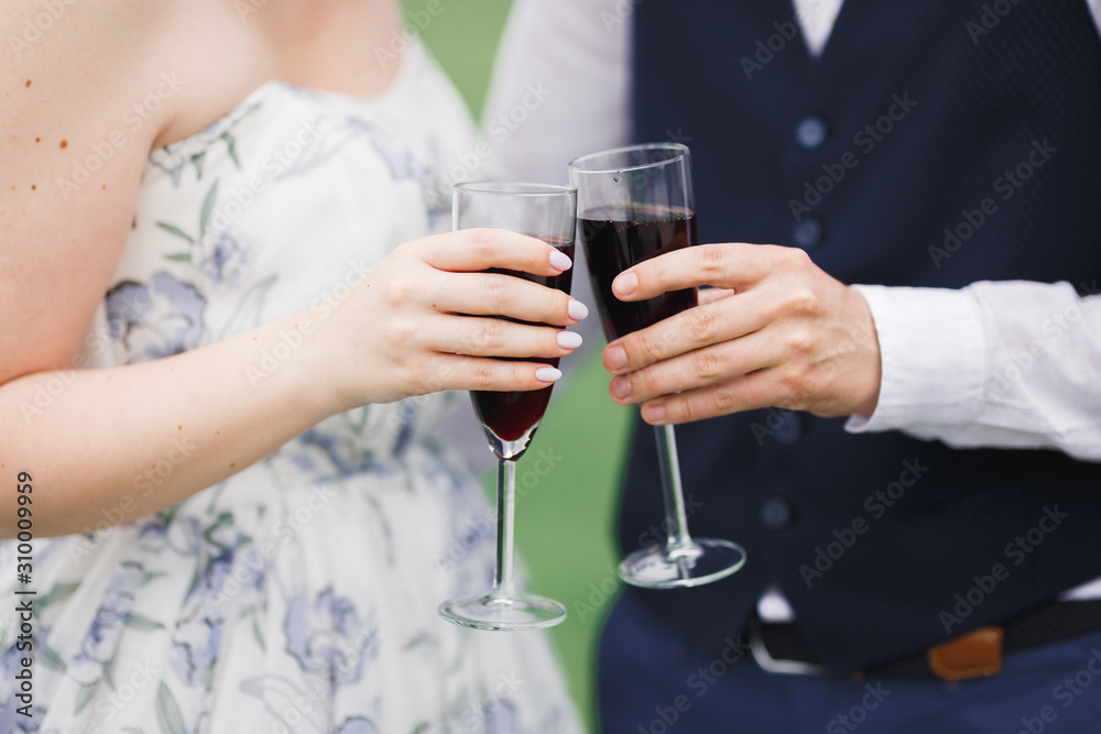 Bride and groom holding glasses with champagne and clink Bride and groom holding glasses with champagne and clink
