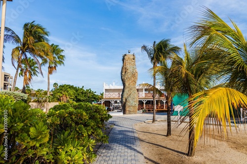 Beautiful exterior view of outdoor hotel area. Training wall for climbimg surrounded of green palm trees on blue sky background. Willemstad. Curacao.  photo