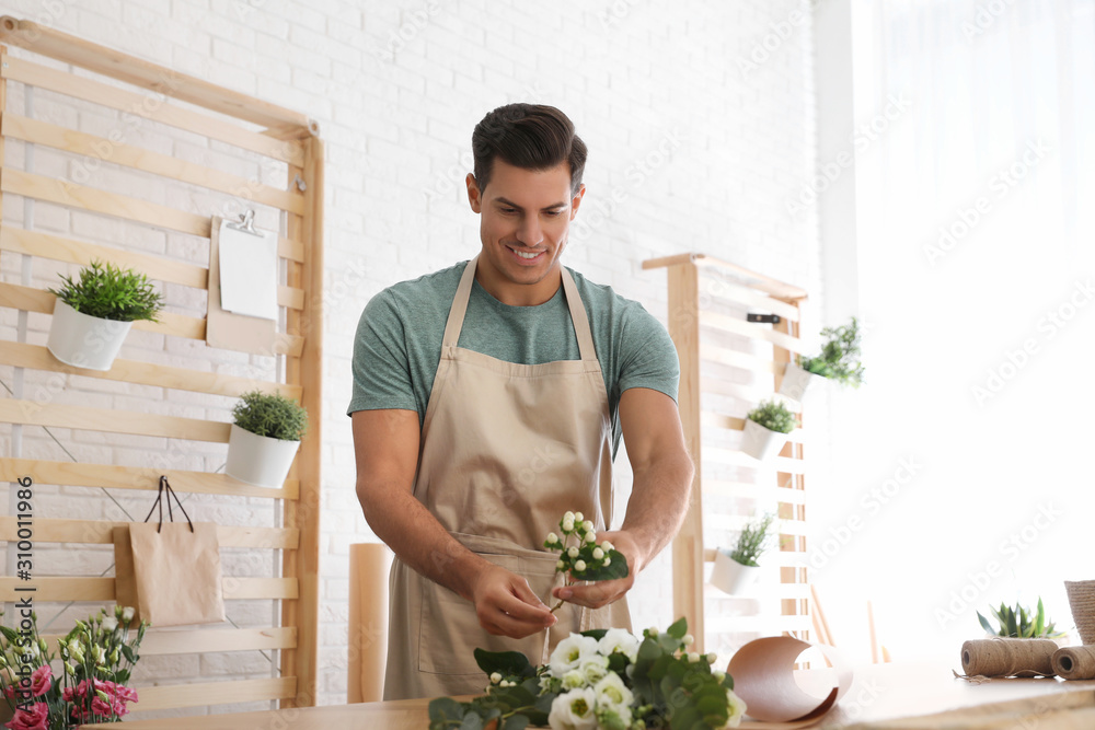 Florist making beautiful bouquet at table in workshop Florist making beautiful bouquet at table in workshop