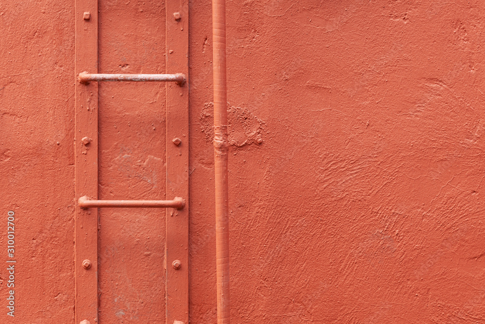 Obraz premium A closeup of a ladder and pipe against a painted textured wall